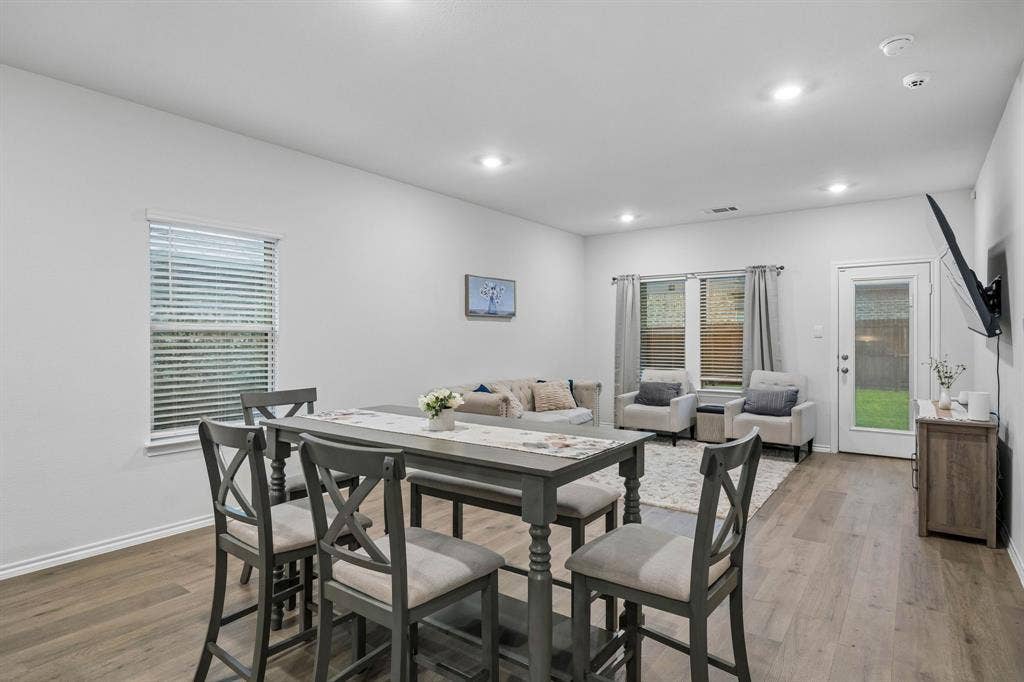 3719 Mildren Bend, Crandall, TX 75114 Spacious open-concept living area featuring wood-finish flooring, recessed lighting, and ample natural light from multiple windows
