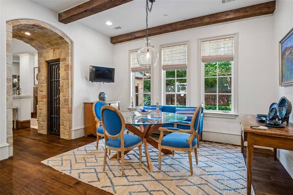 5222 Stonegate Road, Dallas, TX 75209 Wood-finish flooring, exposed wood ceiling beams, stone archway, and three large windows