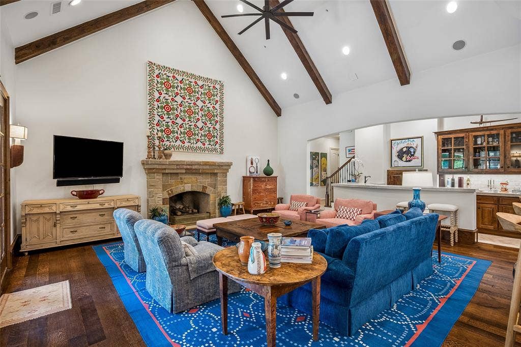 5222 Stonegate Road, Dallas, TX 75209 Vaulted ceiling with exposed wood beams, stone-clad fireplace, wood-finish flooring, recessed lighting, and a built-in wet bar with cabinetry