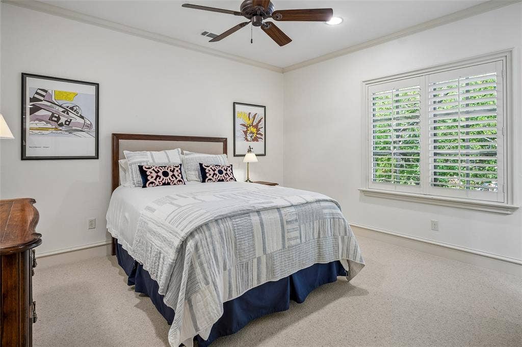 5222 Stonegate Road, Dallas, TX 75209 Bedroom suite #5 Textured carpet flooring, crown molding, a ceiling fan with light, and a window with plantation shutters
