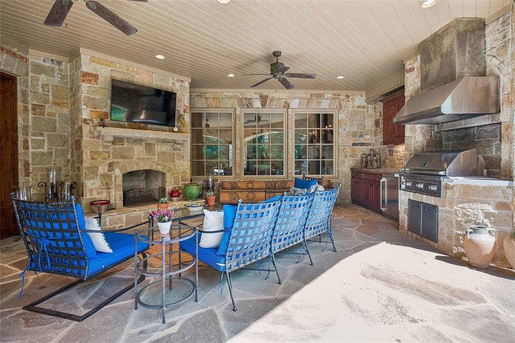 5222 Stonegate Road, Dallas, TX 75209 Covered patio featuring a stone fireplace, built-in outdoor grill, integrated range hood, and planked ceiling with recessed lighting