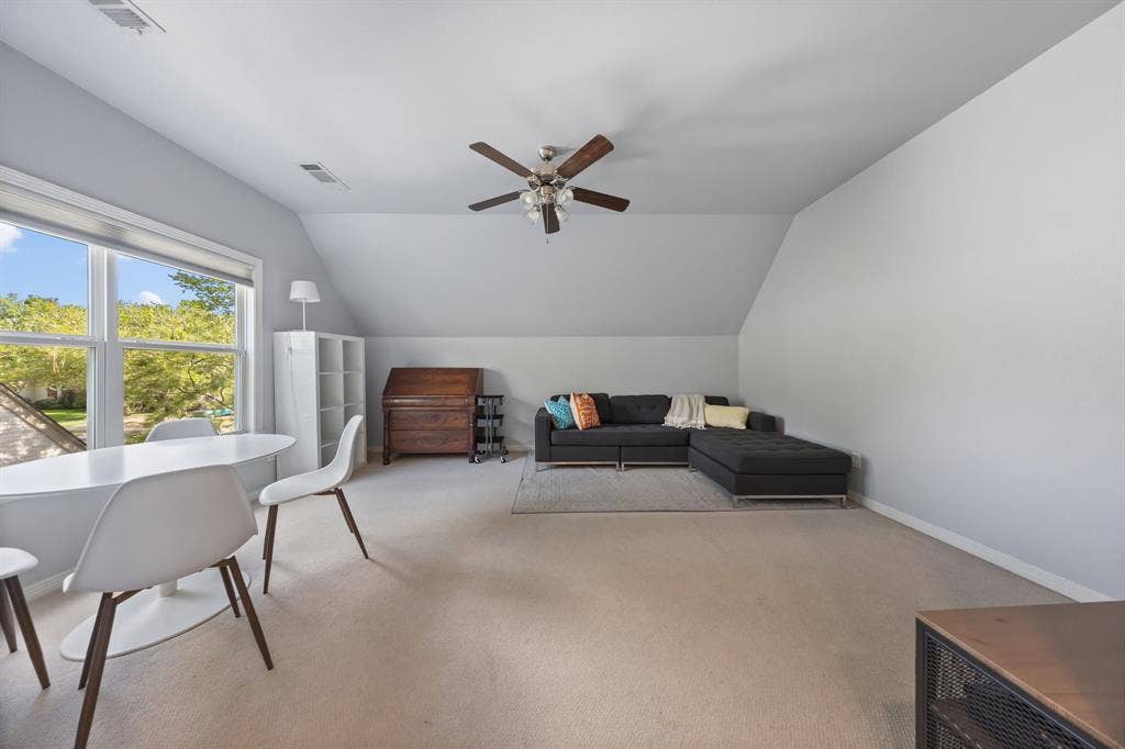 5709 Kenwood Avenue, Dallas, TX 75206 Sloped ceilings, neutral carpet, large windows, ceiling fan, and built-in shelving