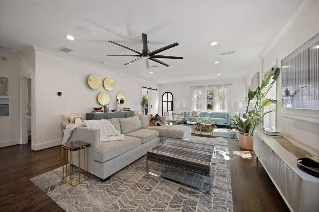5709 Kenwood Avenue, Dallas, TX 75206 Spacious living area featuring dark wood-finish flooring, recessed lighting, a modern ceiling fan, crown molding, and an arched interior doorway