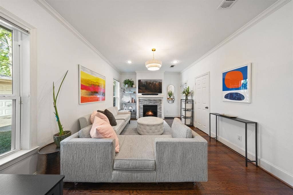 5709 Kenwood Avenue, Dallas, TX 75206 Hardwood flooring, recessed lighting, crown molding, white walls, and a stone-clad fireplace
