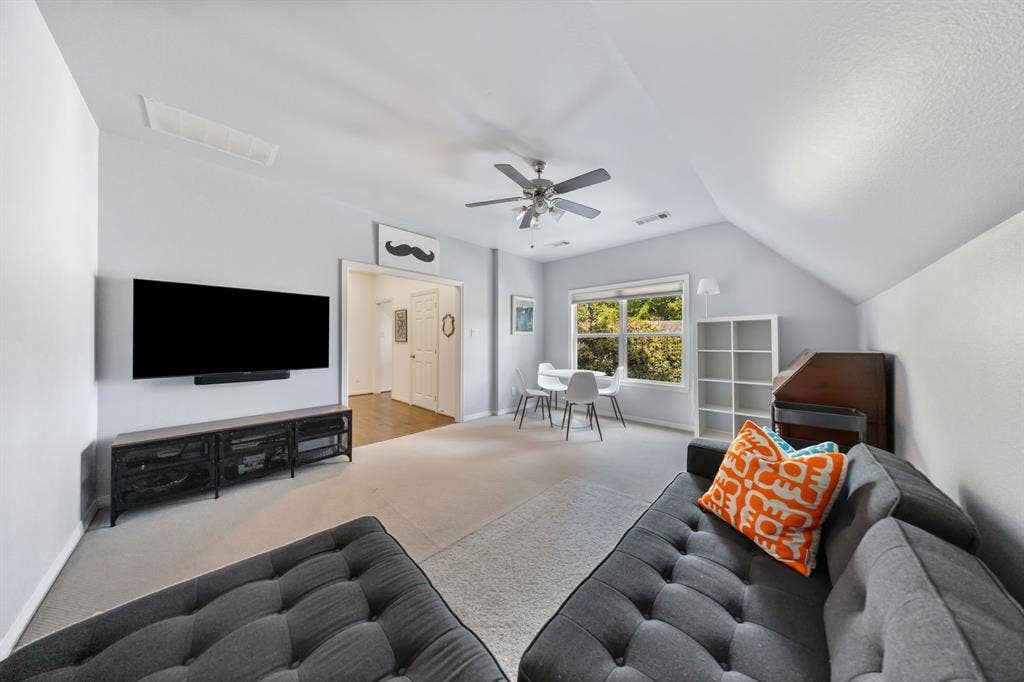 5709 Kenwood Avenue, Dallas, TX 75206 Spacious carpeted room featuring a ceiling fan, vaulted ceilings, and a window with exterior views