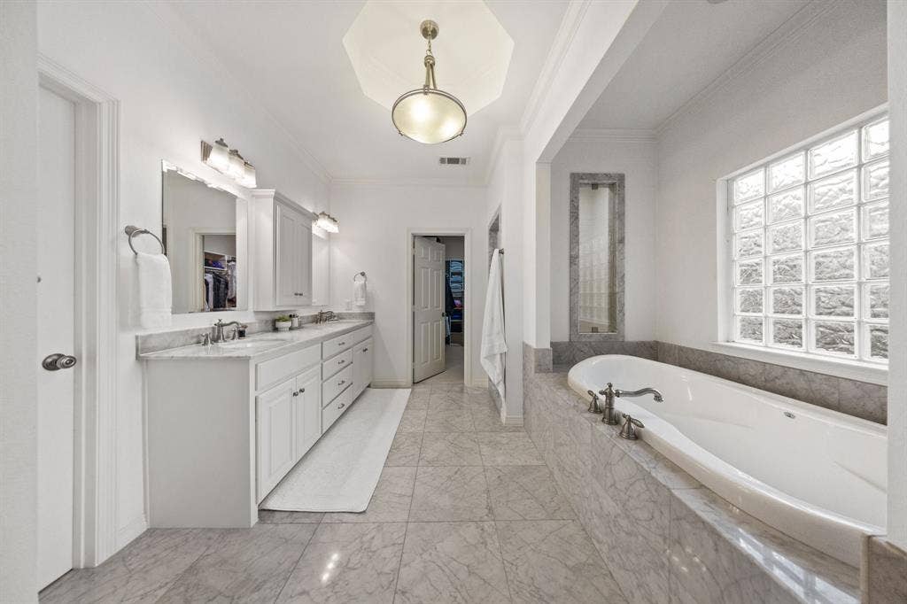 5709 Kenwood Avenue, Dallas, TX 75206 Double vanity with white cabinetry, integrated sinks, and polished chrome fixtures