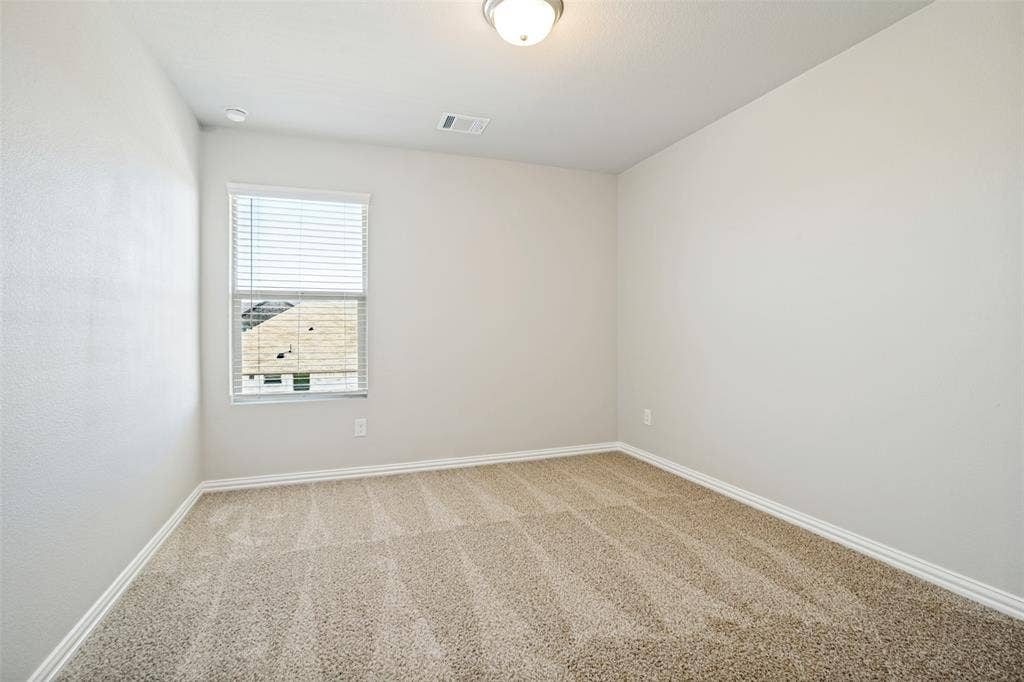 2403 Rocky Mountain Drive, Royse City, TX 75189 Neutral-toned carpeting, white walls, and a window with blinds