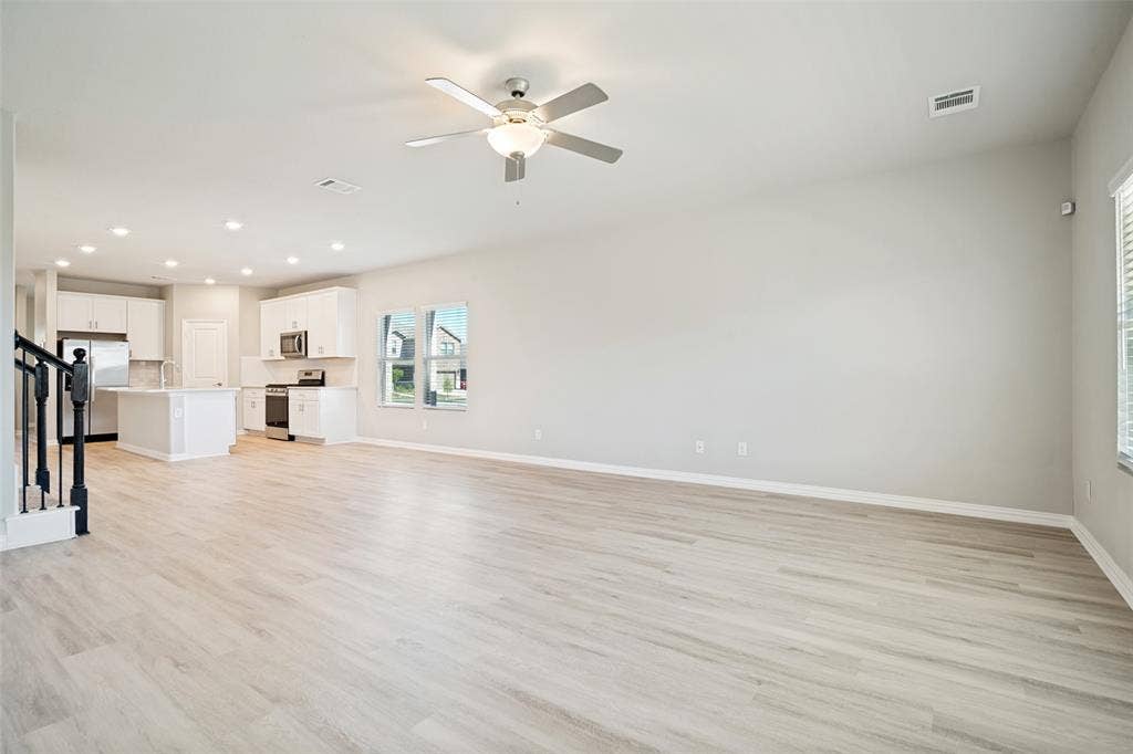 2403 Rocky Mountain Drive, Royse City, TX 75189 Light wood-finish flooring, white cabinetry, stainless steel appliances, recessed lighting, and a ceiling fan