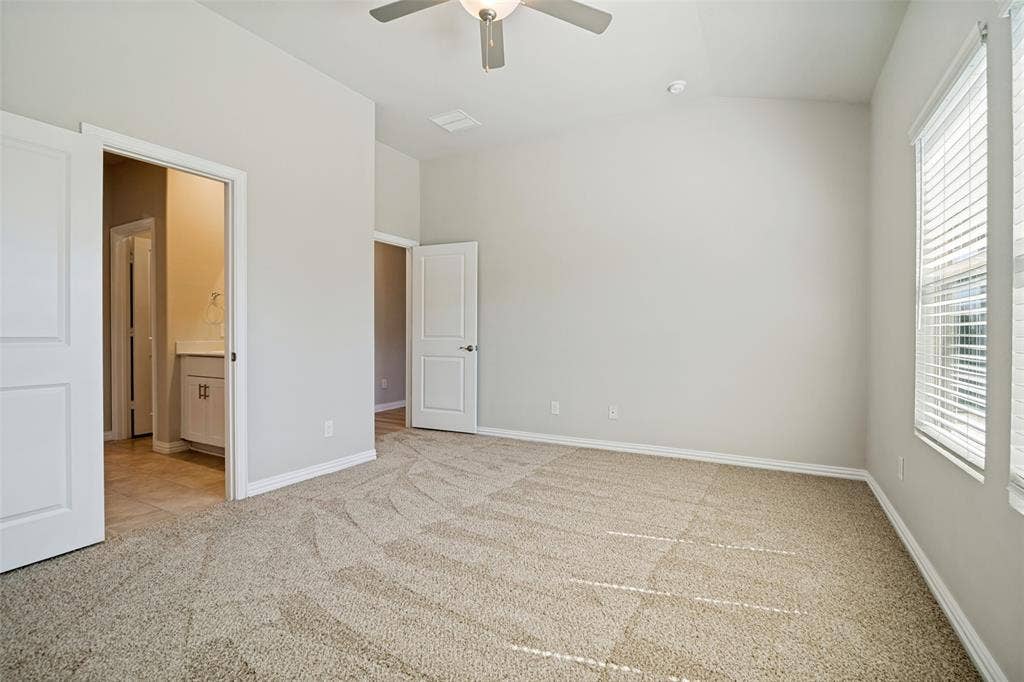 2403 Rocky Mountain Drive, Royse City, TX 75189 Vaulted ceiling with a ceiling fan, light-colored carpet, multiple windows with blinds, and white interior doors