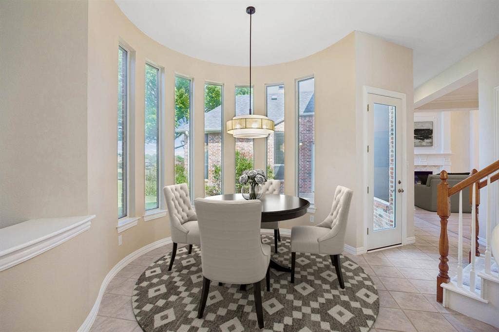 1106 Hills Creek Drive, McKinney, TX 75072 The graceful curved lines found through out the home are repeated in the casual dining area. Enjoy gorgeous views of the backyard. The room also enjoys a whimsical light fixture and the pony wall on the left of the picture can provide additional serving area between the kitchen, nook and sitting room. (Virtually staged to show potential.)