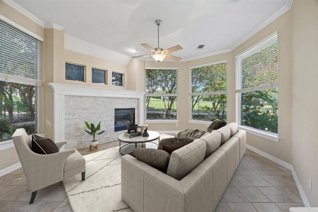 1106 Hills Creek Drive, McKinney, TX 75072 The family room at the back of the home also enjoys the curved lines found in the home. The large windows overlook mature trees and the golf course beyond. The fireplace with gas logs and stacked stone surround provide a cozy feel for the room. Other features include ceiling fan, crown molding and easy care tile flooring. (Virtually staged to show potential.)