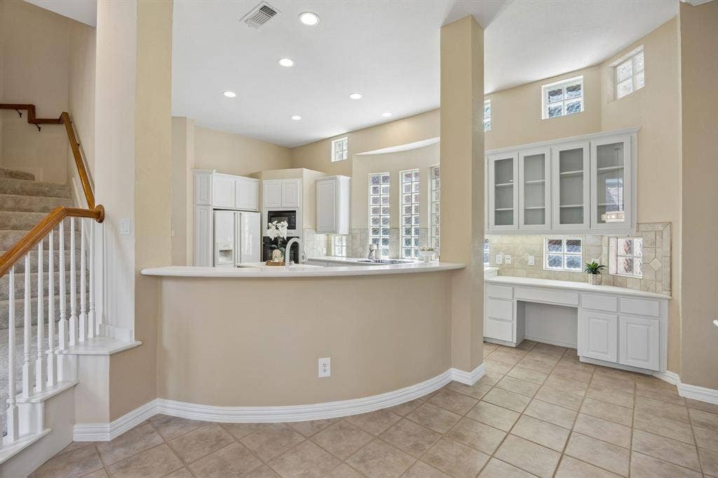1106 Hills Creek Drive, McKinney, TX 75072 As the kitchen flows into the casual dining area you will find a built in desk and additional glass front cabinets. The house boasts a second staircase!