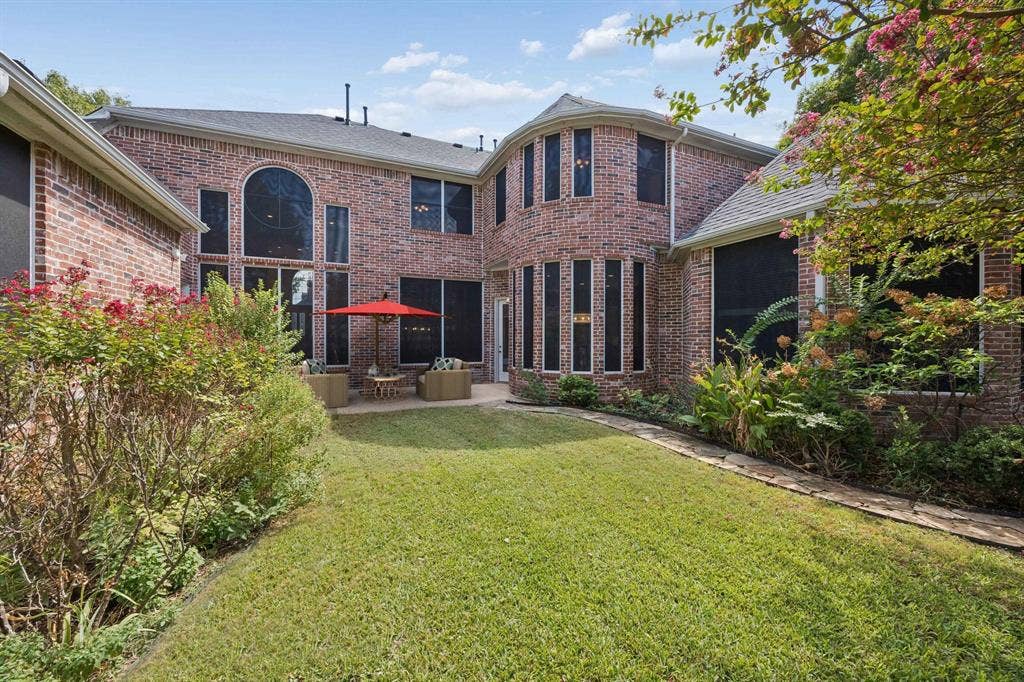 1106 Hills Creek Drive, McKinney, TX 75072 Looking toward the back of the home you find a large patio area and landscaped beds.