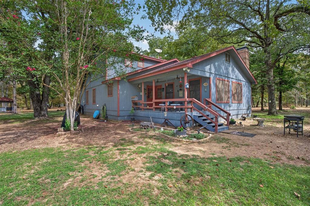 Charming cottage-style home nestled among mature shade trees on expansive grounds