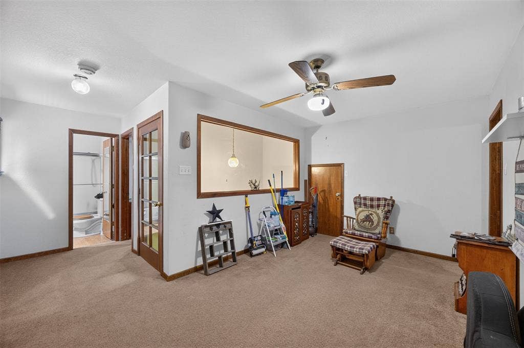 Carpeting throughout, wood-finish trim, ceiling fan, and a pass-through window