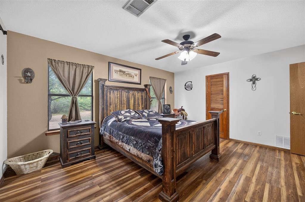 Wood-finish flooring, ceiling fan with integrated lighting, and multiple windows