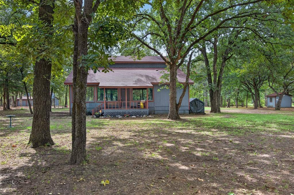 Wooded lot with mature trees, screened porch, and an outbuilding