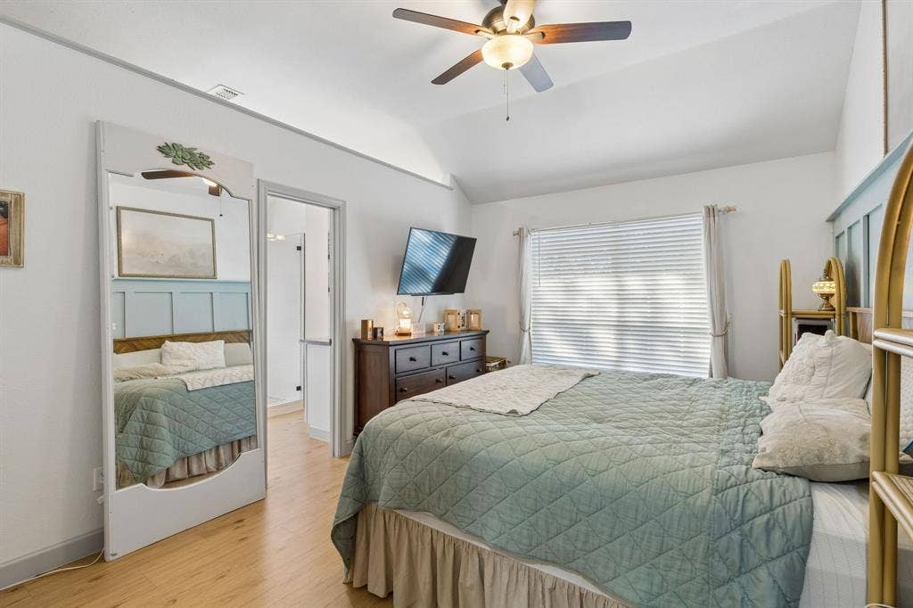 1111 Hyde Park Drive, McKinney, TX 75069 Welcome to the primary bedroom! When you enter you will see a large window, LVP flooring, a ceiling fan, and the entrance to the ensuite bath.