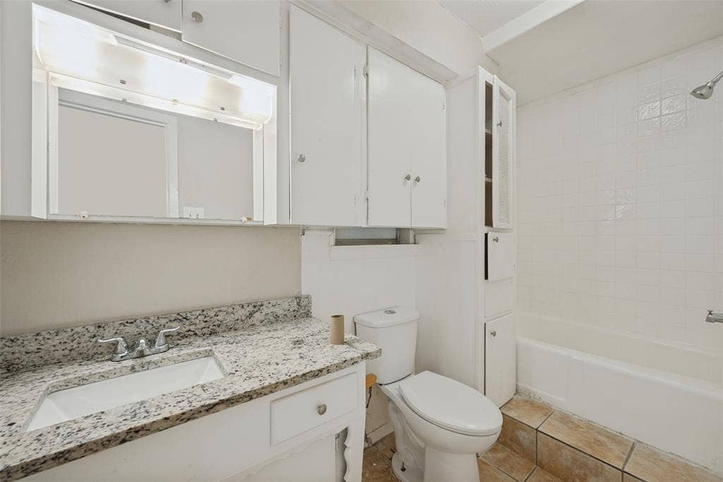 213 W Dorris Drive, Grand Prairie, TX 75051 White vanity with integrated sink, speckled countertop, and chrome faucet