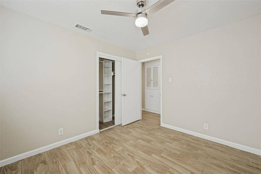 213 W Dorris Drive, Grand Prairie, TX 75051 Wood-finish flooring, ceiling fan with integrated lighting, and a built-in closet system