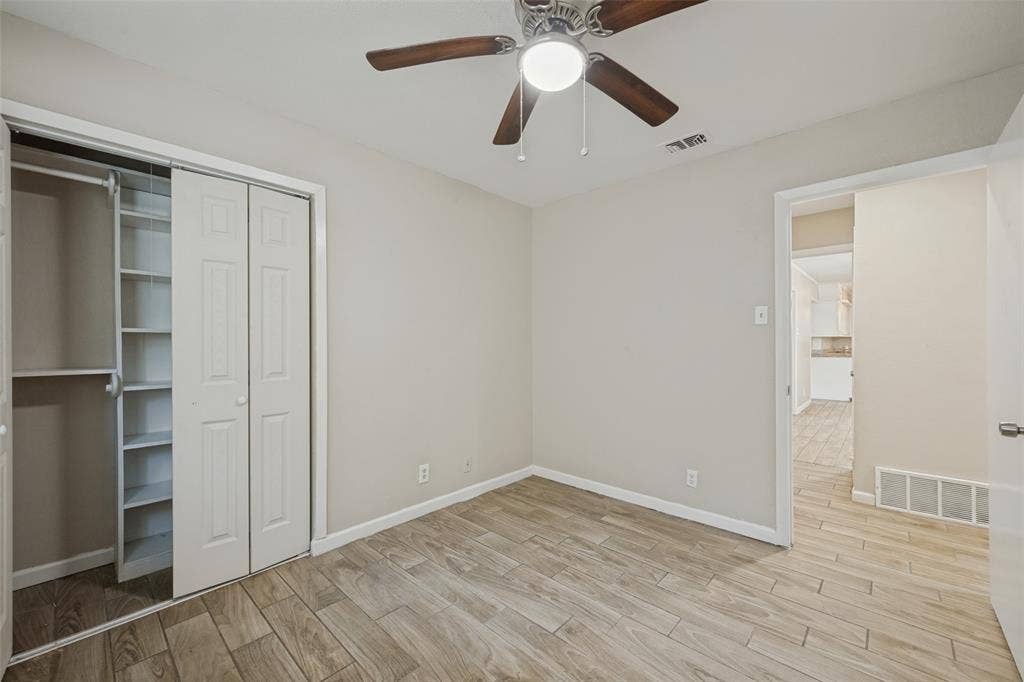 213 W Dorris Drive, Grand Prairie, TX 75051 Wood-finish flooring throughout, ceiling fan with integrated lighting, bi-fold closet doors, and built-in shelving