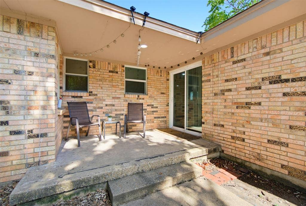 1816 Boyd Street, Dallas, TX 75224 Covered patio with brick exterior, concrete flooring, and a sliding glass door