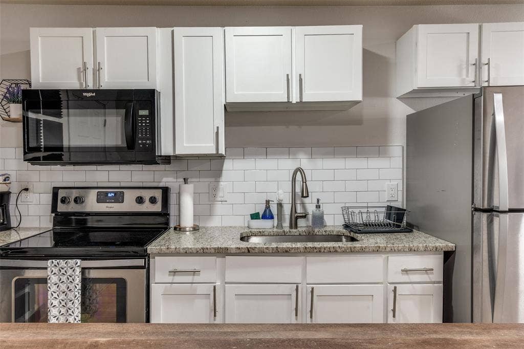 1816 Boyd Street, Dallas, TX 75224 ADU- White shaker cabinetry, stainless steel appliances, granite countertops, and a subway tile backsplash