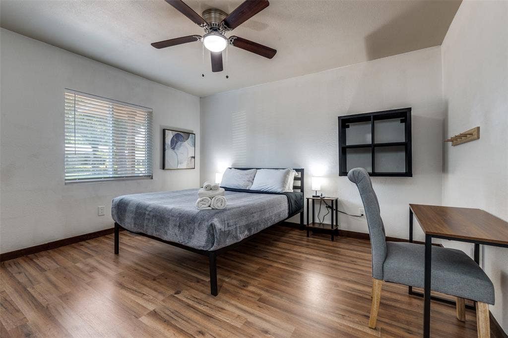 1816 Boyd Street, Dallas, TX 75224 Wood-finish flooring, ceiling fan with integrated lighting, window with horizontal blinds, built-in wall shelving, and wall-mounted coat rack