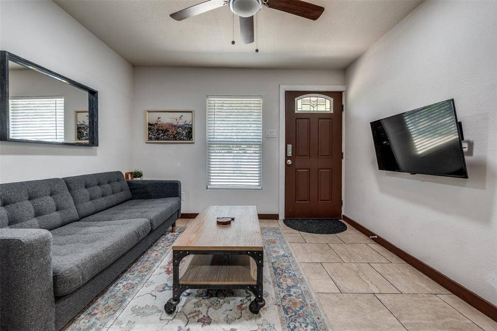 1816 Boyd Street, Dallas, TX 75224 ADU- Smooth tile flooring, ceiling fan, white walls, and a wood-paneled door with decorative glass inlay
