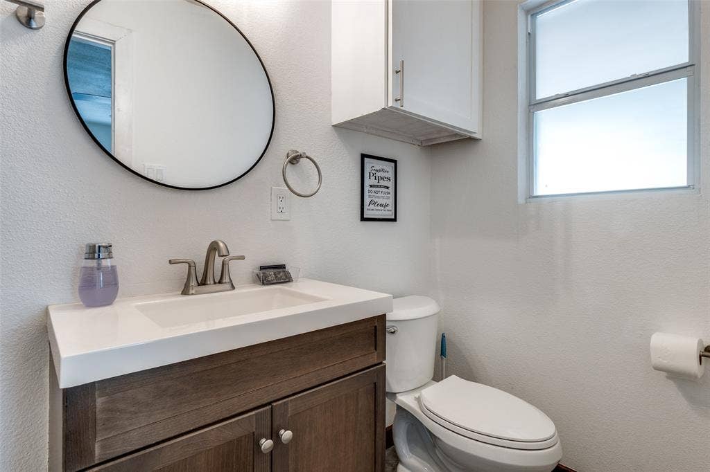 1816 Boyd Street, Dallas, TX 75224 Vanity with a rectangular undermount sink, brushed nickel faucet, and wood-finish cabinetry