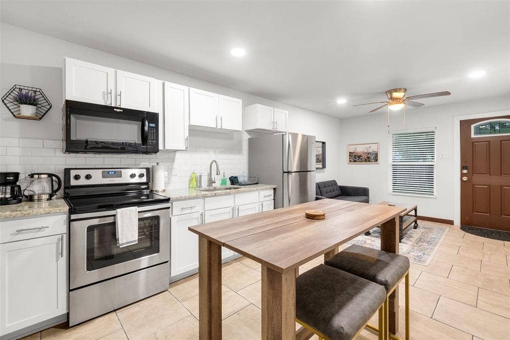1816 Boyd Street, Dallas, TX 75224 ADU- Stainless steel appliances, white subway tile backsplash, white cabinetry, recessed lighting, and tile flooring