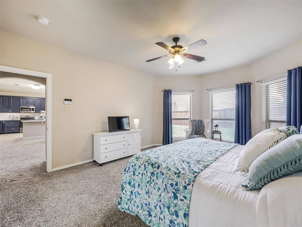 8374 Cain River Drive, Frisco, TX 75035 Multiple windows brighten the generously sized primary bedroom, offering ample space for bedroom furnishings and a sitting area.