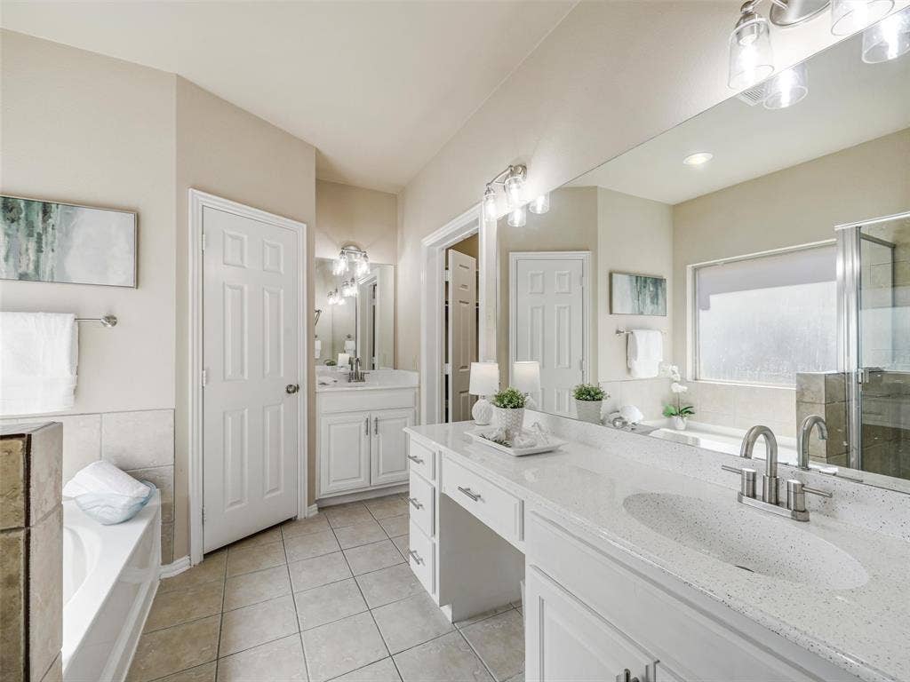 8374 Cain River Drive, Frisco, TX 75035 White vanity cabinetry, generous counter space, and large mirrors create a bright and functional space for daily routines.