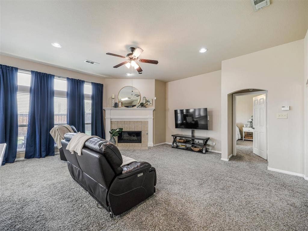 8374 Cain River Drive, Frisco, TX 75035 Spacious living room offers a high ceiling, recessed lighting, a ceiling fan, and a fireplace framed by a classic white mantel.