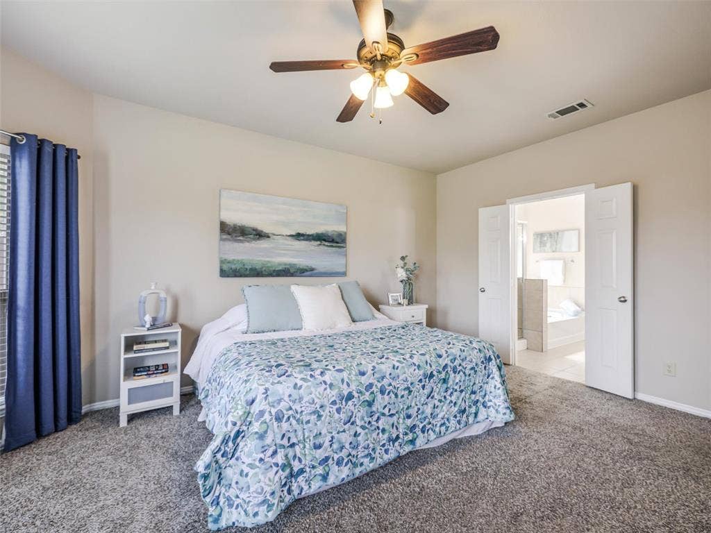 8374 Cain River Drive, Frisco, TX 75035 Inviting primary suite features neutral walls, carpeting, and double doors leading to the adjoining private bathroom.