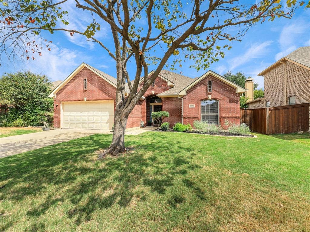 8374 Cain River Drive, Frisco, TX 75035 A spacious front lawn and mature tree frame the home’s attractive brick exterior.