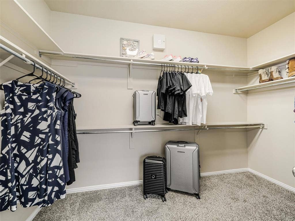 8374 Cain River Drive, Frisco, TX 75035 Generous walk-in closet features wraparound shelving and multiple hanging rods for convenient clothing and accessory storage.