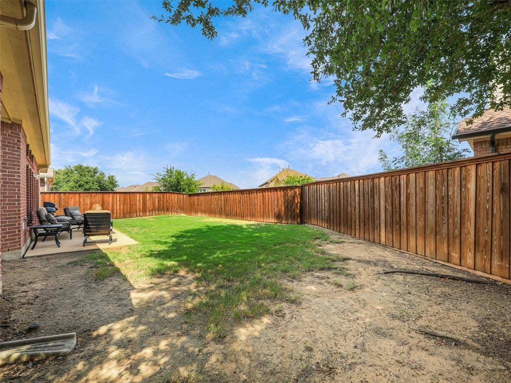 8374 Cain River Drive, Frisco, TX 75035 Wide backyard view highlights wood fencing, shade from a mature tree, and room for gardening or outdoor recreation.