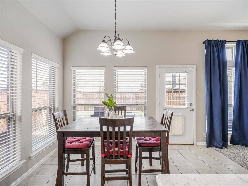 8374 Cain River Drive, Frisco, TX 75035 Sun-filled breakfast nook features surrounding windows, a decorative chandelier, tile flooring, and direct access to the backyard.