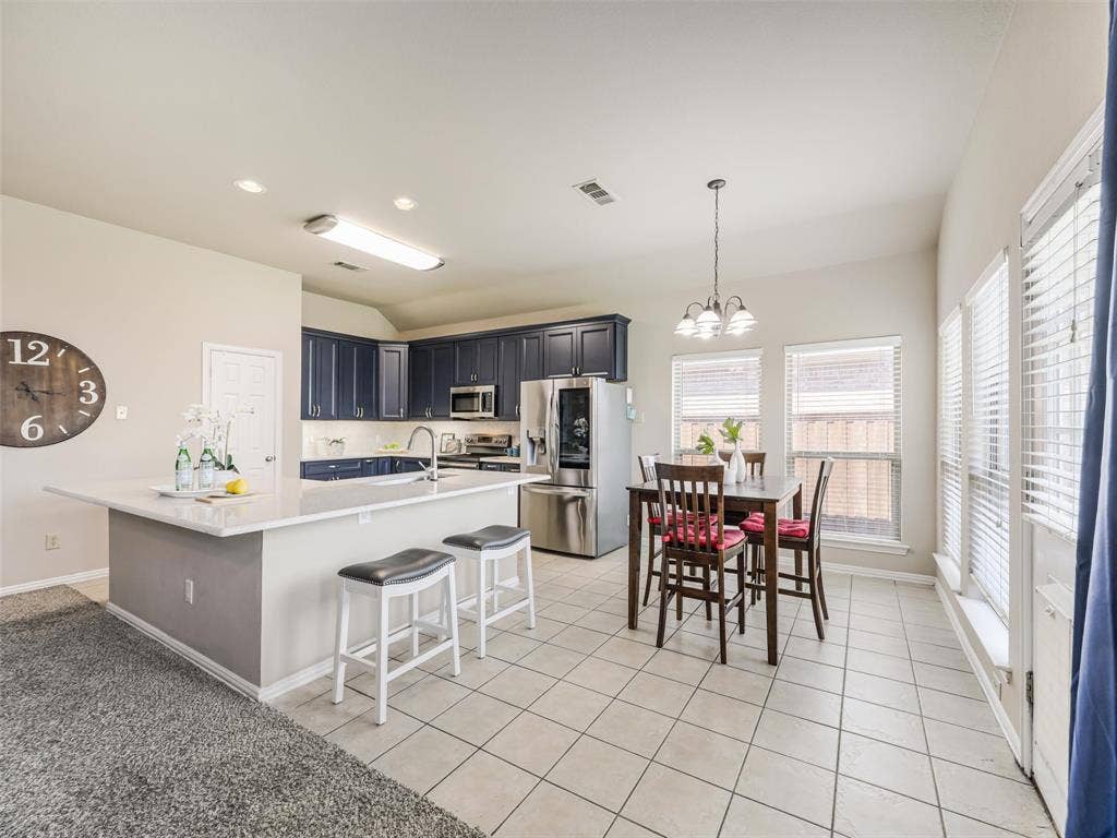 8374 Cain River Drive, Frisco, TX 75035 Breakfast bar seating and an adjoining dining nook provide convenient gathering spaces in this open kitchen, with windows bringing in abundant natural light.