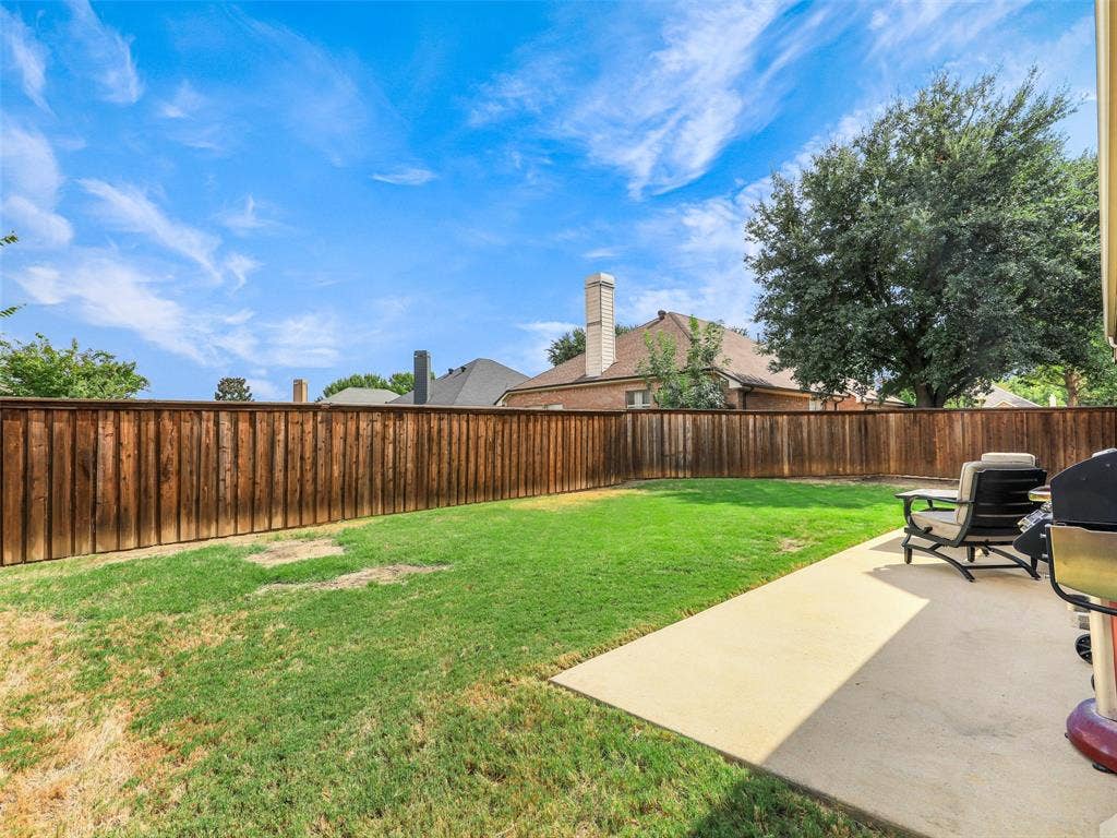 8374 Cain River Drive, Frisco, TX 75035 Fenced backyard offers an open lawn and concrete patio with space for outdoor seating, grilling, and relaxing.