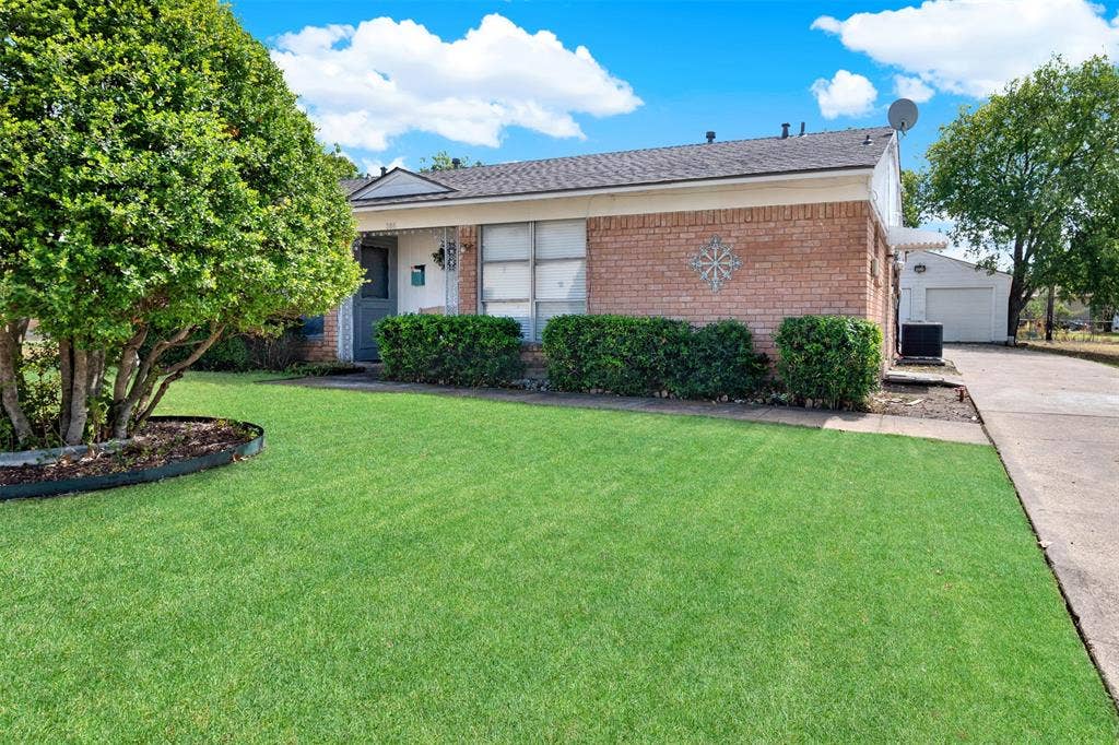 306 Hilltop Avenue, #A, Richardson, TX 75081 Ranch-style house with a front yard, cooling unit, and a garage