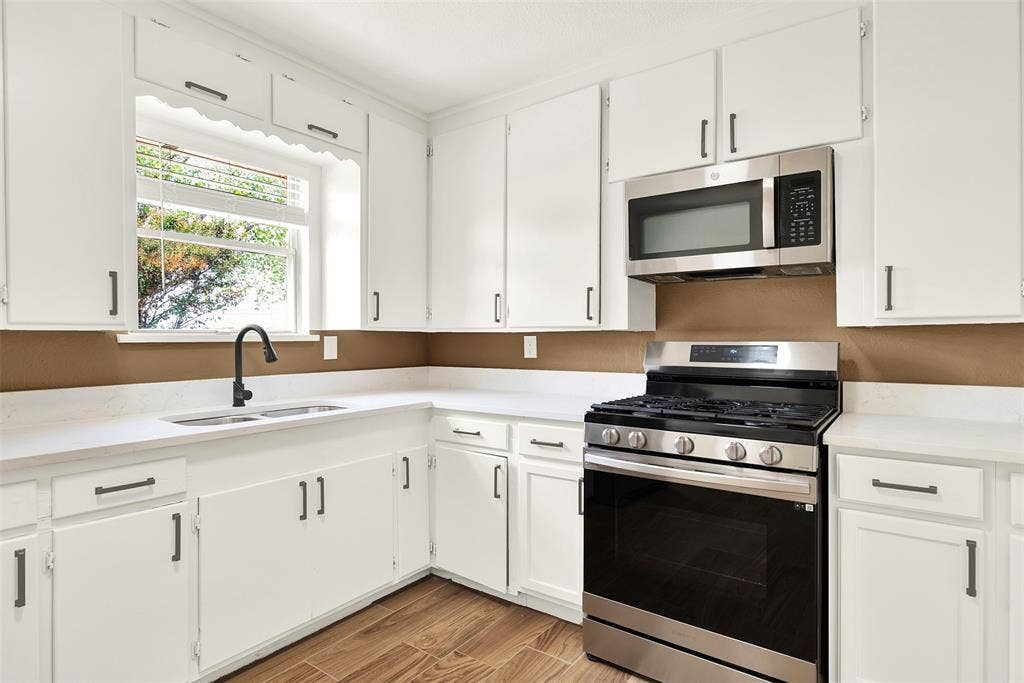 306 Hilltop Avenue, #A, Richardson, TX 75081 Kitchen with light wood-type flooring, sink, stainless steel appliances, and white cabinets