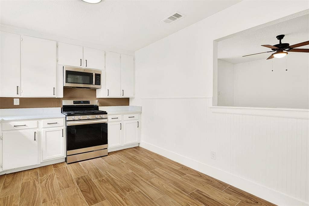 306 Hilltop Avenue, #A, Richardson, TX 75081 Kitchen featuring ceiling fan, appliances with stainless steel finishes, white cabinetry, and light hardwood / wood-style flooring