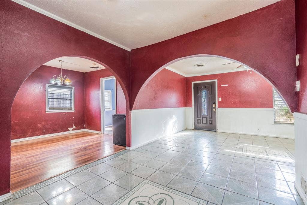 934 Indian Hills Drive, Grand Prairie, TX 75051 Arched doorways frame distinct living spaces, featuring tile flooring in one area and wood-finish flooring in another