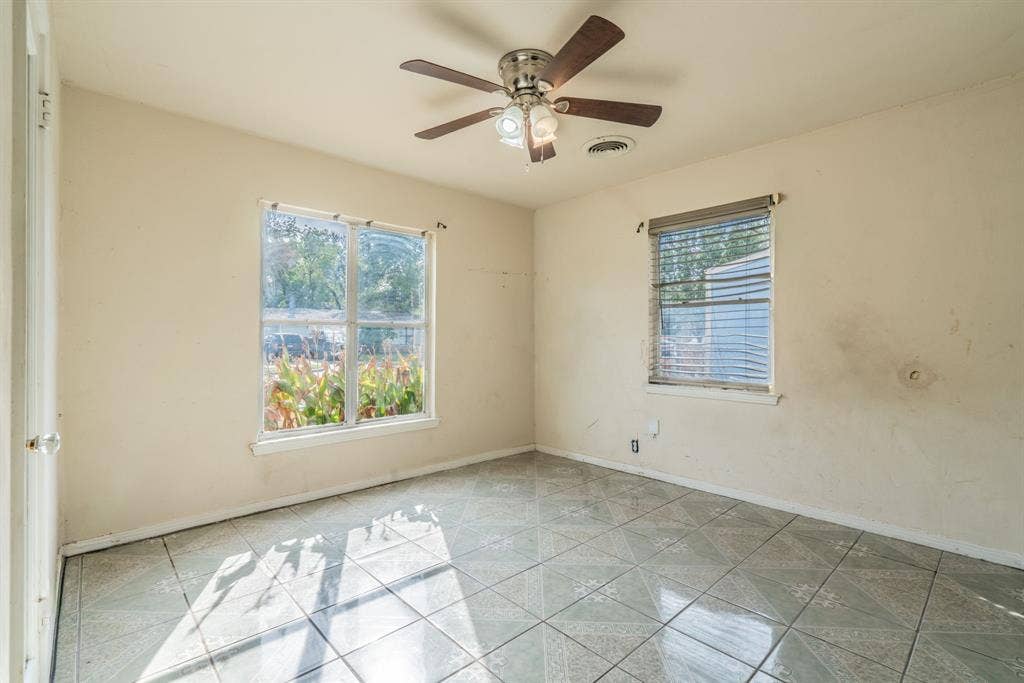 934 Indian Hills Drive, Grand Prairie, TX 75051 Patterned tile flooring, ceiling fan with integrated lighting, two windows with blinds, and painted walls