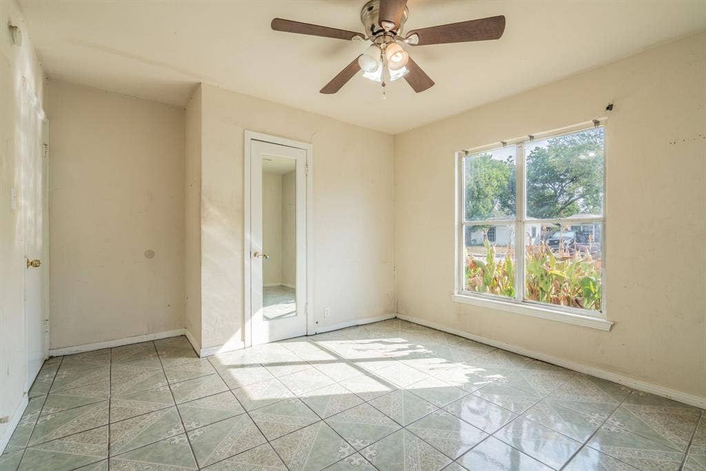 934 Indian Hills Drive, Grand Prairie, TX 75051 Ceramic tile flooring, ceiling fan with integrated lighting, and a large window providing ample natural illumination
