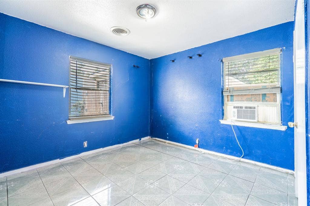 934 Indian Hills Drive, Grand Prairie, TX 75051 Tile flooring, two windows with blinds, wall-mounted air conditioning unit, ceiling-mounted light fixtures