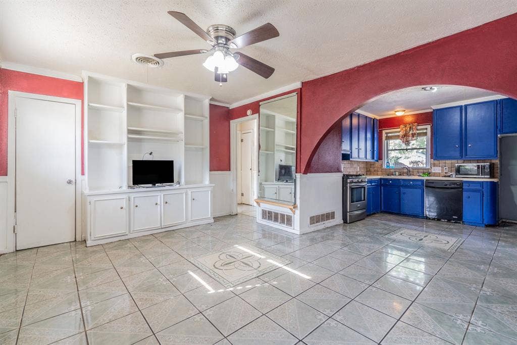 934 Indian Hills Drive, Grand Prairie, TX 75051 Built-in shelving and cabinetry, ceiling fan, tile flooring, kitchen with blue cabinetry, and stainless steel range