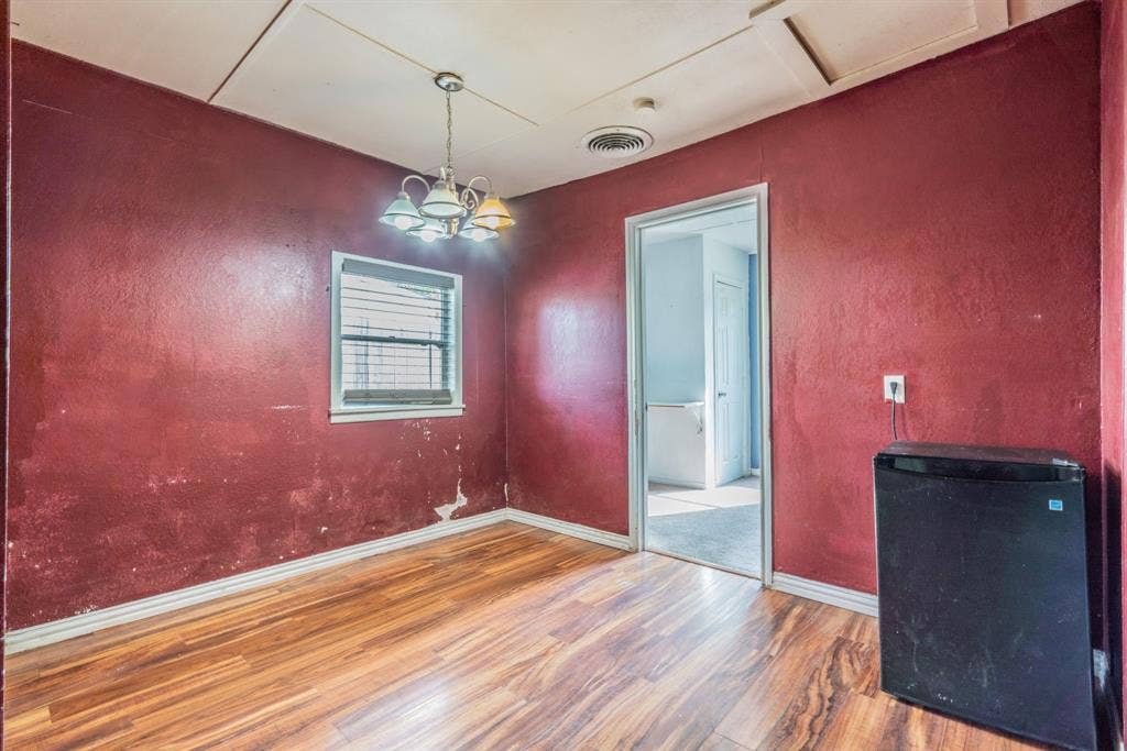 934 Indian Hills Drive, Grand Prairie, TX 75051 Wood-finish flooring with baseboard trim, complemented by an overhead multi-bulb light fixture